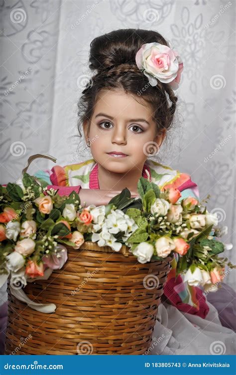 little brunette girl with flowers in her hair and a basket of flowers portrait retro style