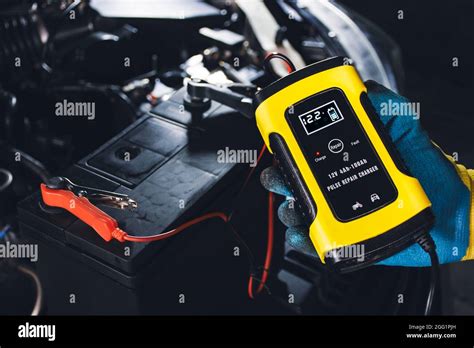 Technician Recharge Car Battery With Automatic Battery Charger In