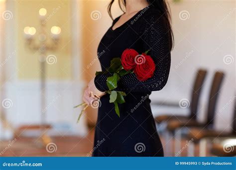 Mujer Con Las Rosas Rojas En El Entierro En Iglesia Imagen De Archivo