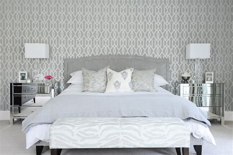 Grey bedrooms have that chic feel of a townhouse hotel about them, especially when covered in delicately patterned wallpaper. Gray Bedroom with Mirrored Nightstands - Transitional - Bedroom - Enviable Designs