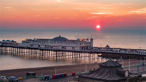 Sunset On Brighton Pier With A Flock Of Birds Editorial Photography