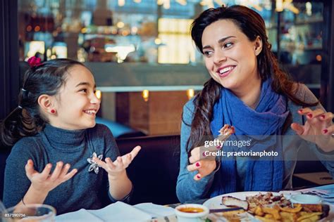 Mother And Daughter Are Eating Pork Ribs In The Restaurant With Hands
