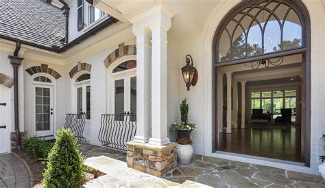 Gorgeous home features a white painted brick exterior accented with balconies over steel framed doors located on the first floor. White Brick House | White Brick Homes And Painted Brick