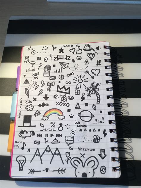 An Open Notebook With Doodles And Symbols On The Cover Sitting On A