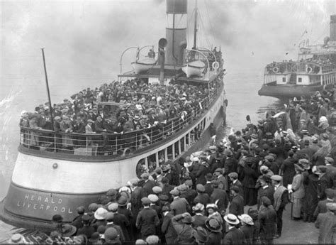 A Large Crowd Of People Standing On The Side Of A Boat
