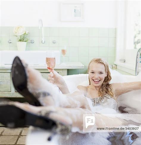 Find the perfect frau badewanne stock photo. Frau im Kleid liegt mit Sektglas in der Badewanne ...
