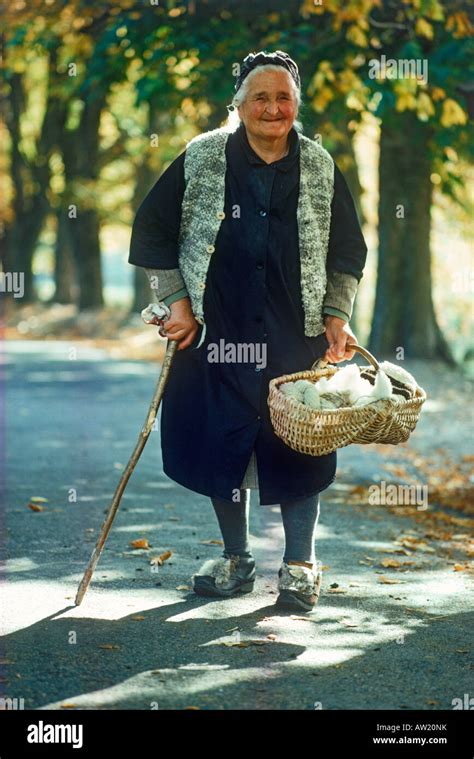 Old Italian Woman Walking Country Road With Basket Of Yarn To Village Near Swiss Border Stock