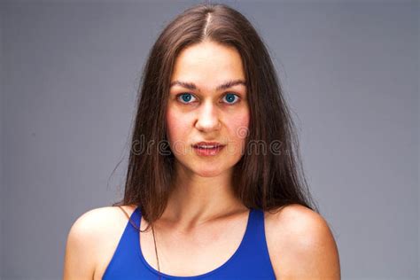 Close Up Portrait Of A Beautiful Young Brunette Girl In A Blue Solid