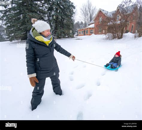 Outdoors At Day Mother Pulling Son On Sledge In Snow Ontario Canada Ontario Canada Winter