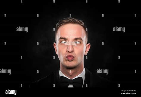 Portrait Of A Young Cross Eyed Businessman With Funny Face Over Dark