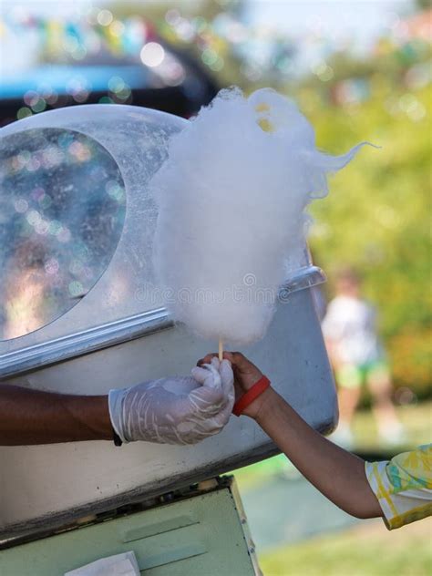 Little Girl Receiving A Big Cotton Candy From The Seller Near The