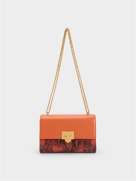 Orange Snake Print Metallic Accent Clutch Charles And Keith Kh