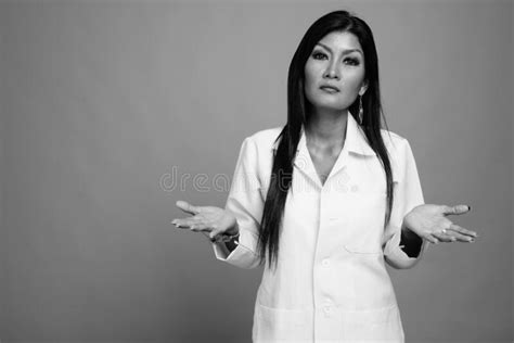 Mature Beautiful Asian Woman Doctor Against Gray Background Stock Photo
