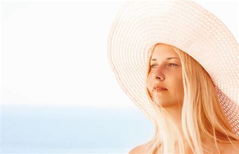 Premium Photo Woman With Blond Hair Wearing Hat Enjoying Seaside And Beach Lifestyle In