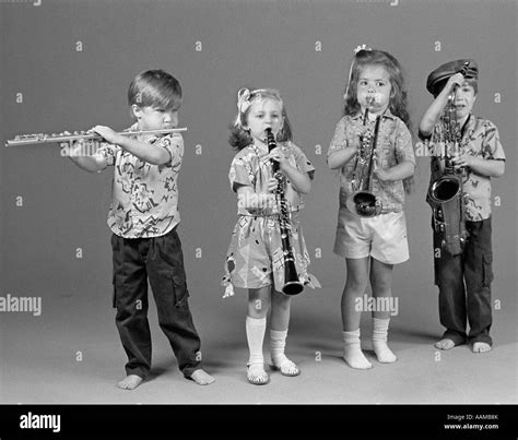 Two Boys And Two Girls Playing Flute Clarinet Trumpet And