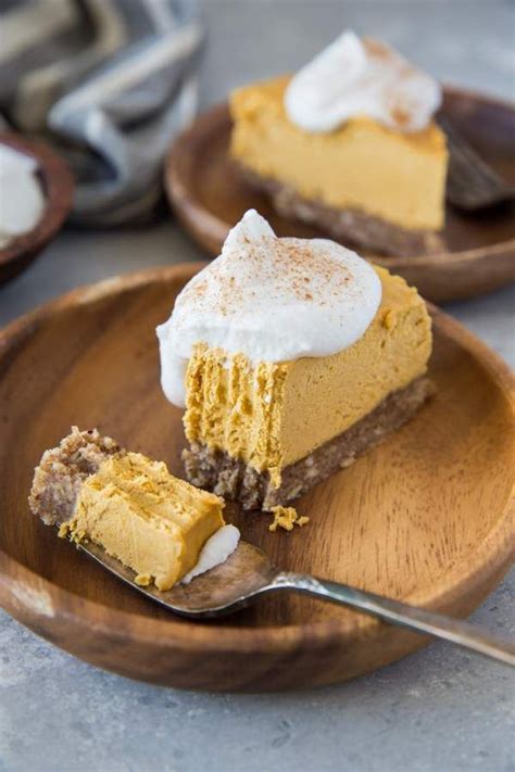 A Piece Of Pumpkin Cheesecake On A Wooden Plate With A Fork