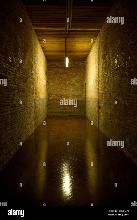 Dead End Hallway With Walls Of Brick And A Single Light Illuminating