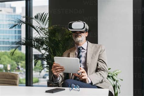 Geschäftsmann Der Einen Virtual Reality Simulator Trägt Und Mit Einem Tablet Pc Am Schreibtisch