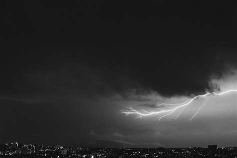 A Long Lightning Bolt Creeping Across The Night Sky Over A City