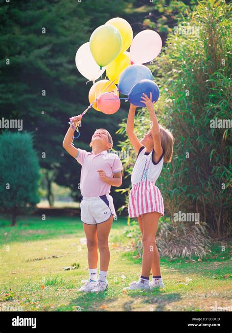 Children Playing With Balloons In A Park Stock Photo Alamy