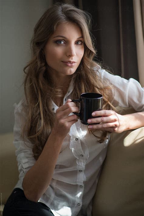 A Young Brunette Relaxing With A Cup Of Coffee Del Colaborador De