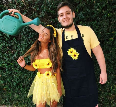 A Man And Woman Dressed In Costumes Posing For A Photo With Sunflowers On Their Hands