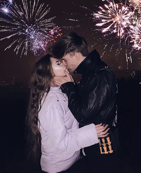A Man And Woman Kissing In Front Of Fireworks