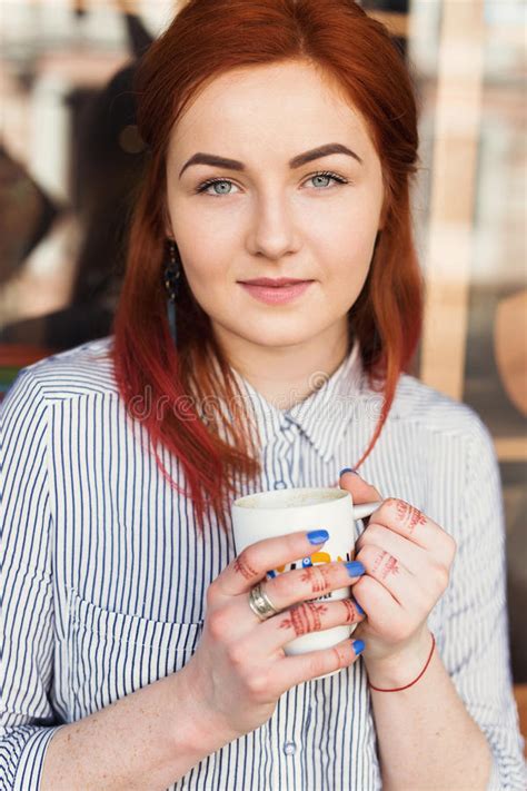 Jonge Aantrekkelijke Vrouw Die Van Een Kop Van Koffie In Koffie Genieten Stock Afbeelding
