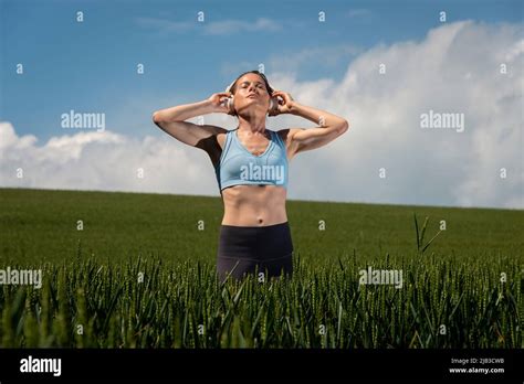 Sporty Fit Woman Standing In A Green Field Wearing A Pair Of
