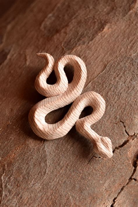 A Wooden Toy Snake Sitting On Top Of A Piece Of Wood