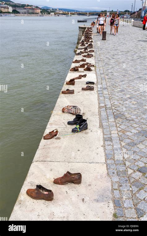 Tourists Visiting The Shoes On The Danube Bank Memorial Conceived By