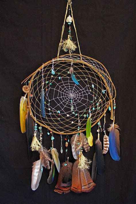 A Dream Catcher With Feathers And Beads Hanging From Its Side On A
