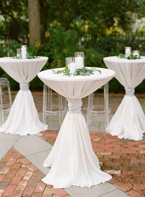 White Pillar Candles And Greenery Atop Cocktail Tables Wedding Cocktail Tables Outdoor
