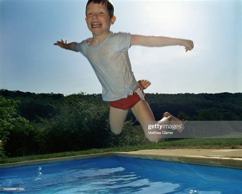Boy Jumping Into Pool Portrait High Res Stock Photo Getty Images