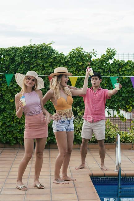 Group Of Friends Having A Pool Party While They Dance Laugh And Drink