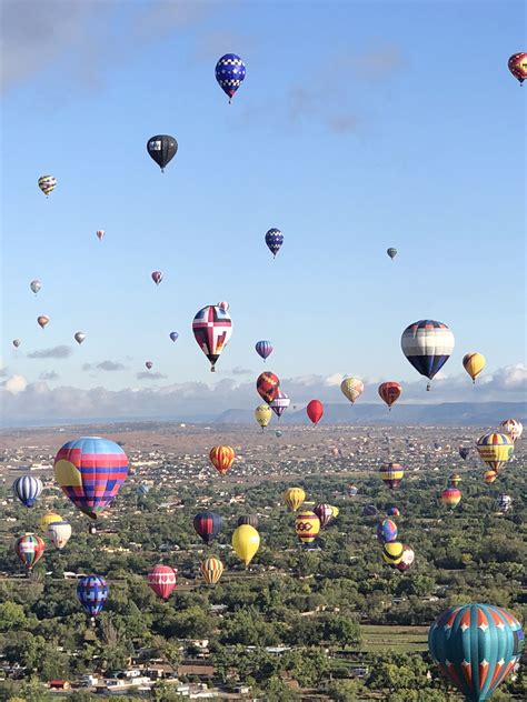 Many Colorful Hot Air Balloons Flying In The Sky Above Trees And Land