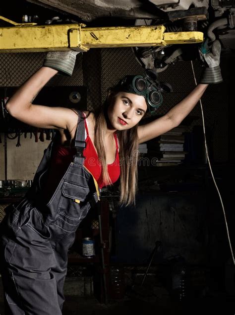 Beautiful Young Female Mechanic Inspecting Car In Auto Repair Shop