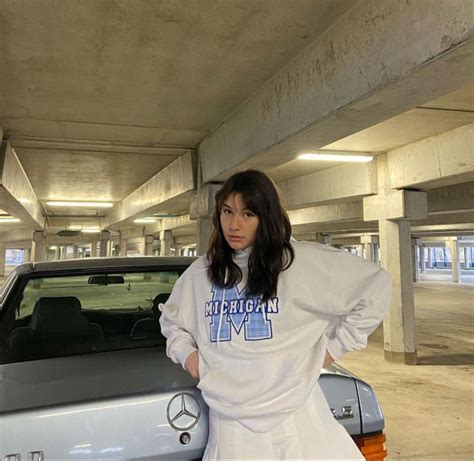 A Woman Standing Next To A Car In A Parking Garage With Her Hands On