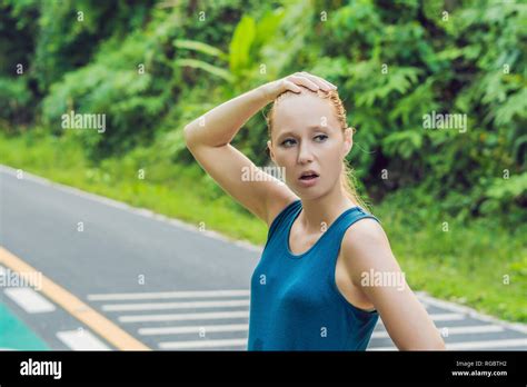 tired runner sweating after running hard in countryside road exhausted sweaty woman after