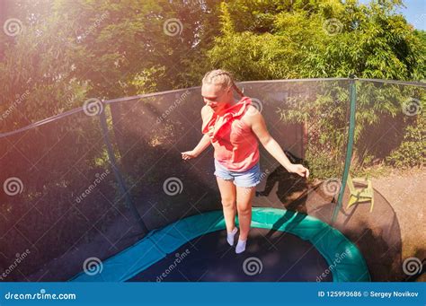 Happy Girl Jumping Up And Down On The Trampoline Stock Photo Image Of