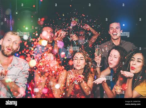 Happy Friends Doing Party Throwing Confetti In Nightclub Group Young People Having Fun