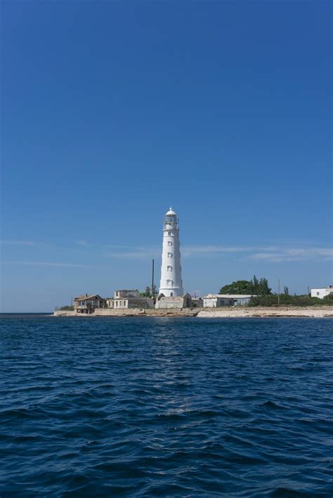 Seascape Of A White Lighthouse At Cape Tarkhankut With A Clear Blue Sky