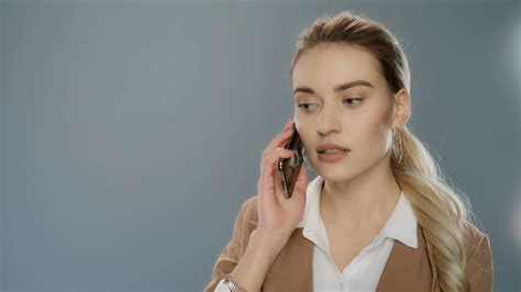 Serious Business Woman Talking Mobile Phone On Gray Background Portrait Of Young Businesswoman
