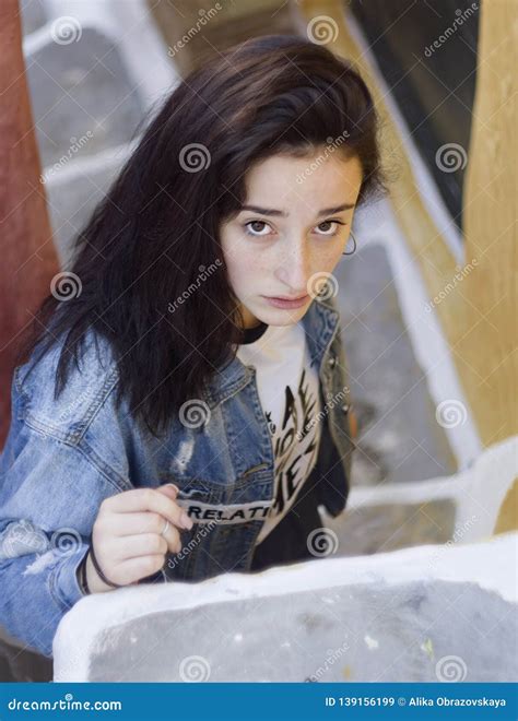 Young Greek Girl On The Steps Of Narrow Streets In The Tourist Area Of