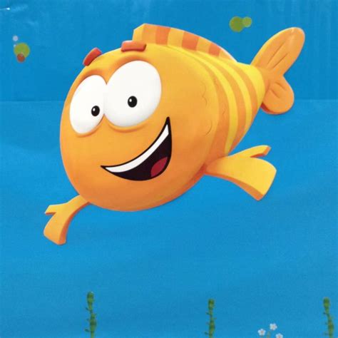 A Yellow Fish With Big Eyes Floating In The Water Near Some Plants And
