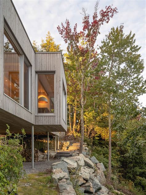 A House In The Forest Clad In Eastern Cedar Siding Is Raised Above The