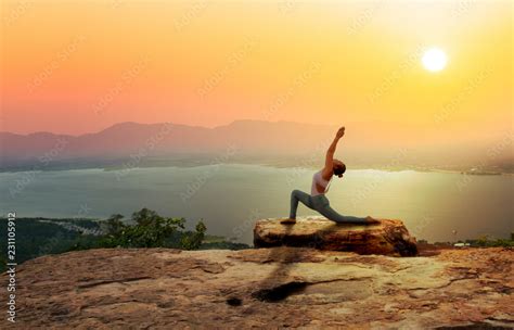 Woman Practice Yoga On Mountain With Sunset Or Sunrise Background Stock