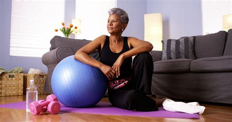 Senior Black Woman Sitting On Floor With Exercise Equipment X10 Therapy