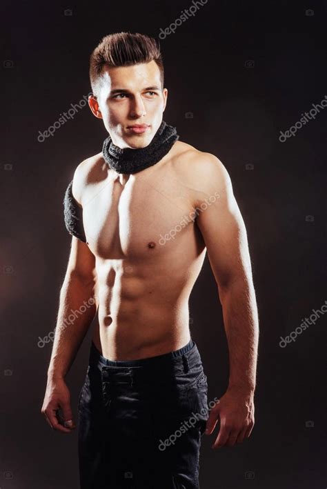 Сексуальный молодой человек с обнаженным туловищем на тёмном фоне стоковое фото ©myronstandret
