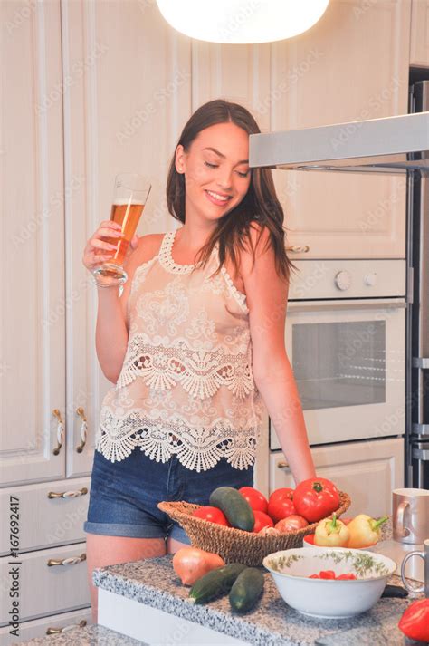 beautiful smiling girl drink beer in the kitchen portrait of cute teenage girl drink cold drink